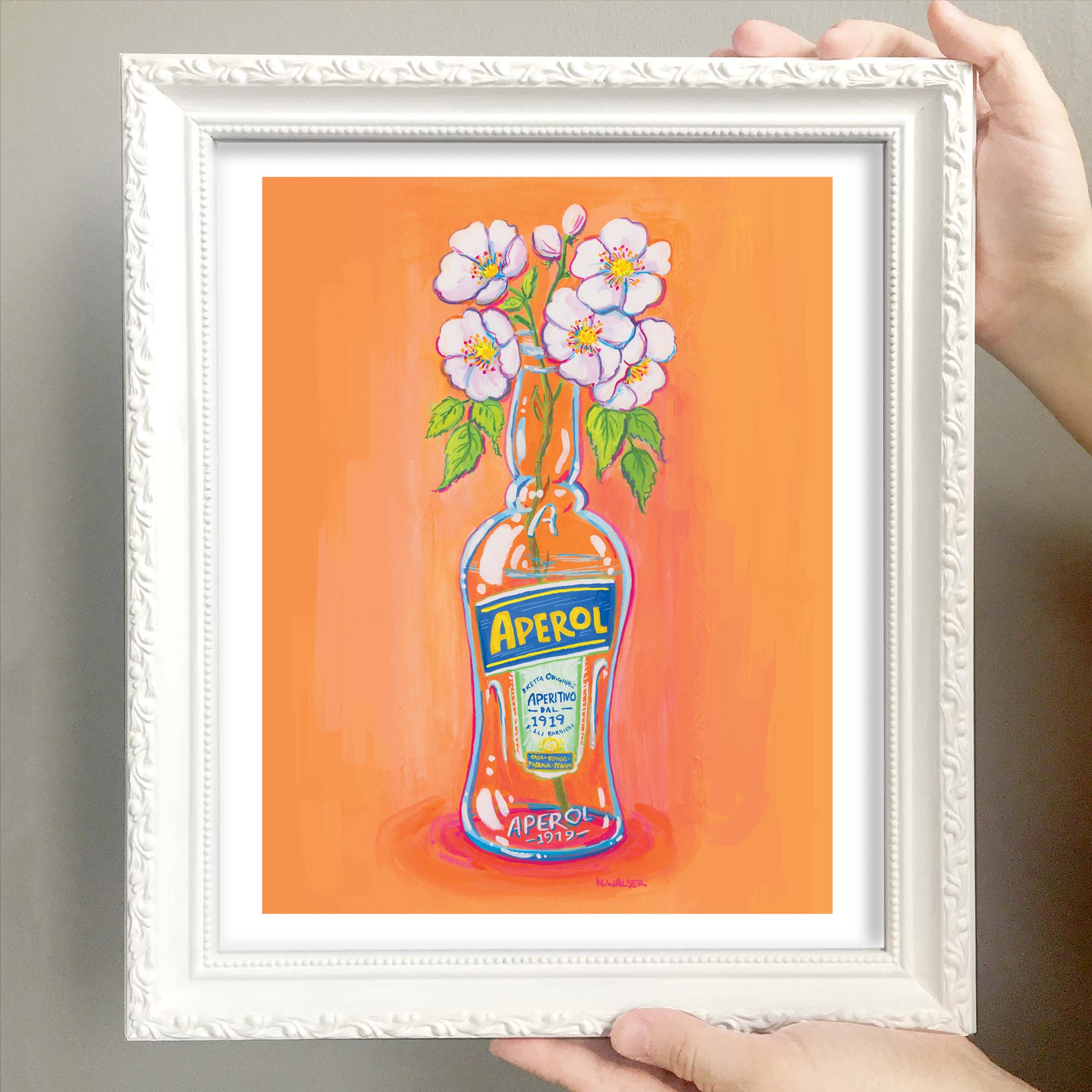 Framed artwork of an Aperol bottle with flowers on an orange background