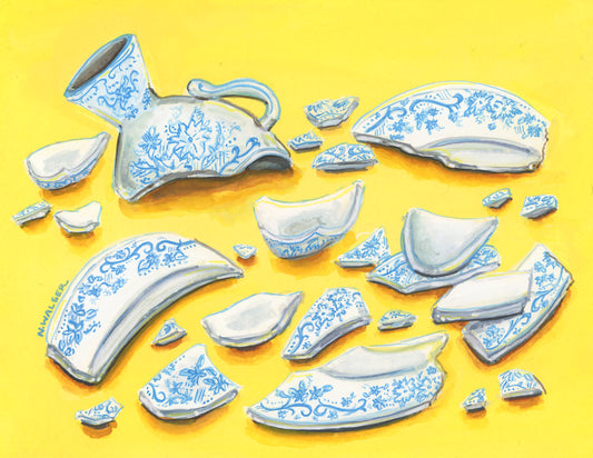 Broken ceramic tea cup pieces with blue patterns on a yellow background