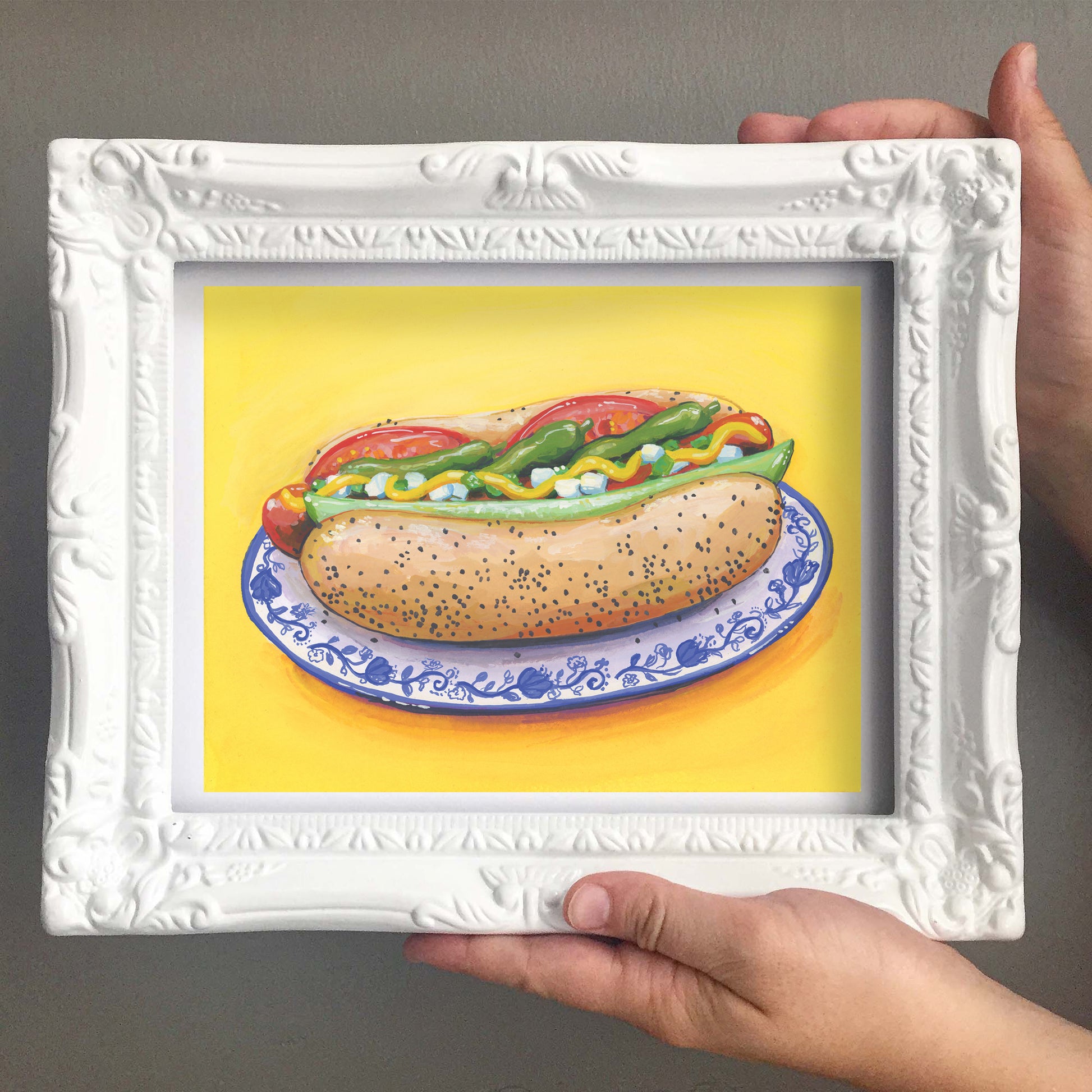 Framed artwork of a Chicago Style hot dog on a yellow background
