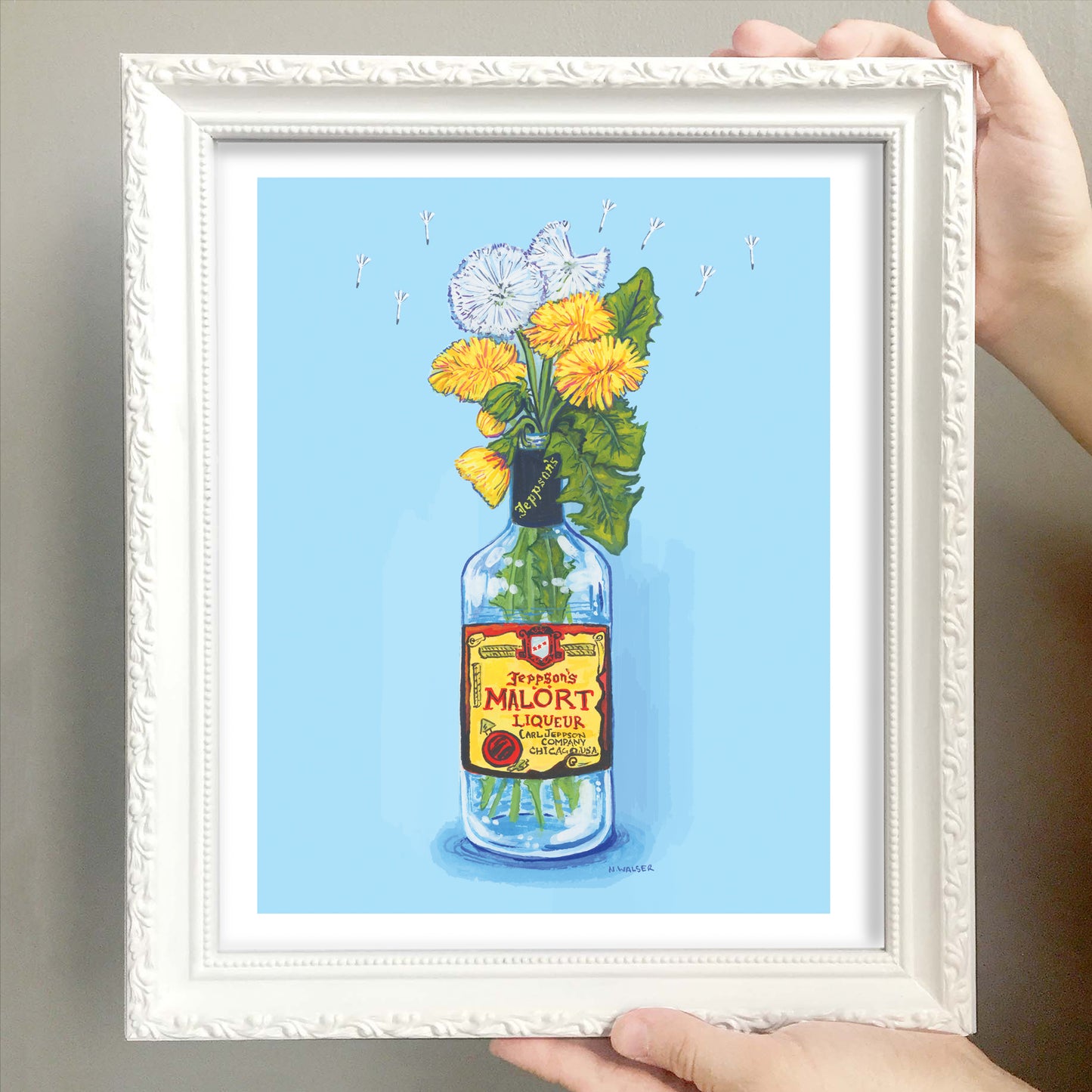 Framed artwork of flowers in a Malort bottle with a label against a blue background