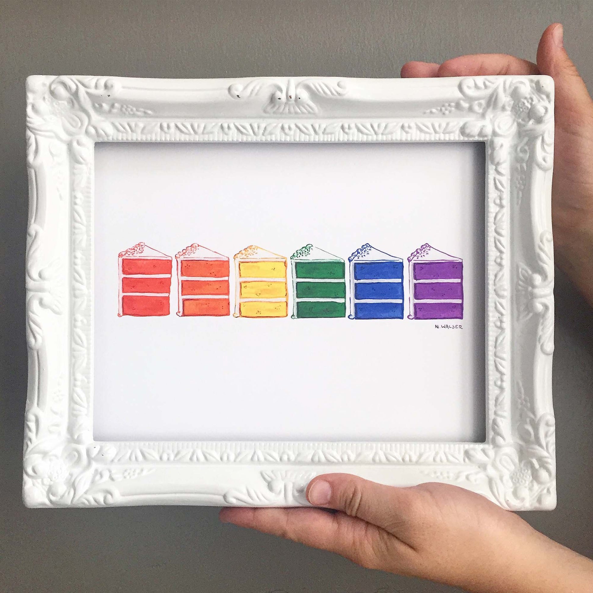 Framed artwork of rainbow-colored cake slices