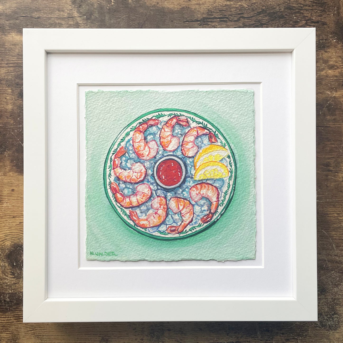 Framed artwork of a shrimp cocktail design on a green background